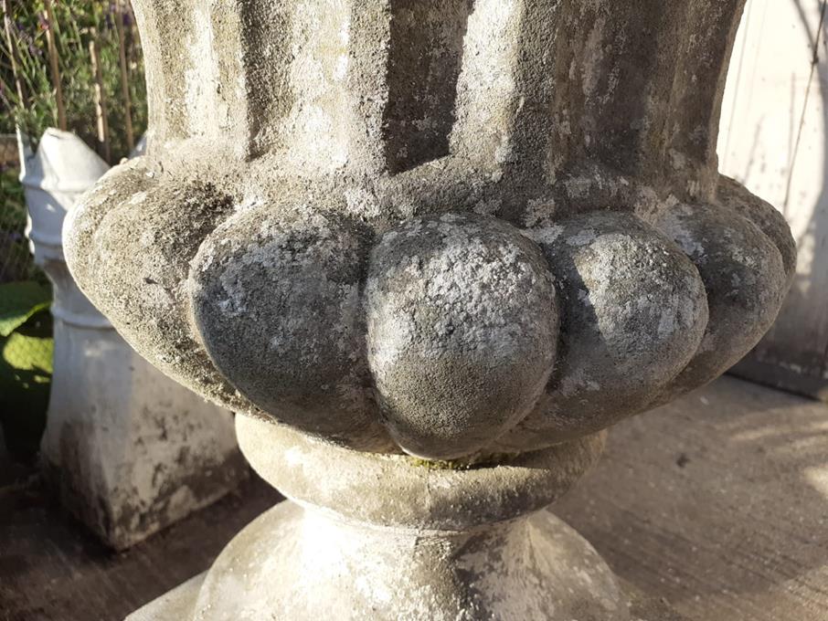 A Pair Of Rams Head Urns On Plinths