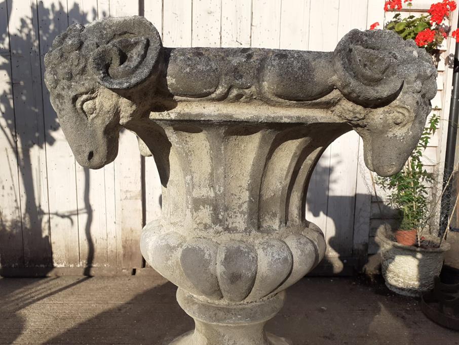 A Pair Of Rams Head Urns On Plinths